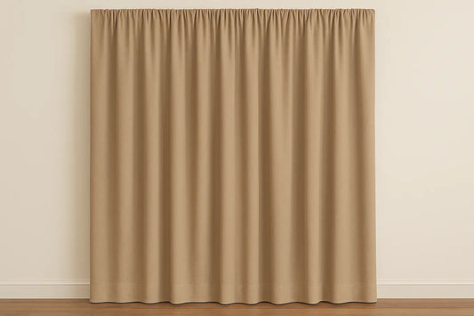 Solid beige curtains with neat pleats hanging against a light wall in a minimal living space