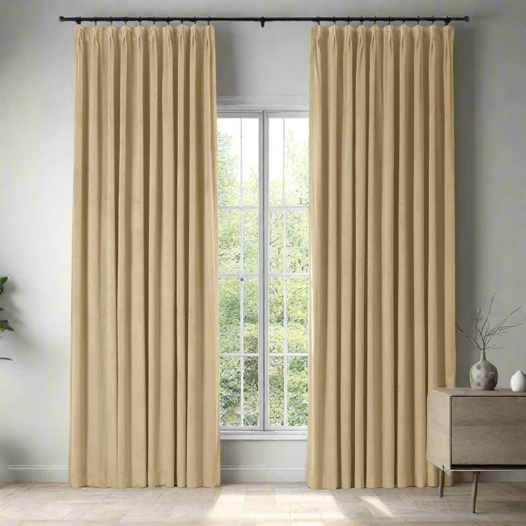 Beige curtains hanging in front of a window with a light interior setting.